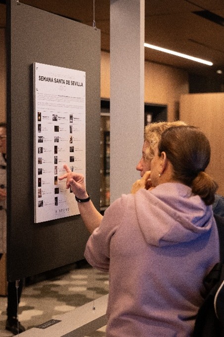 Asistentes observando una fotografía finalista con silueta en contraluz en la Exposición de Semana Santa de Sevilla 2025 