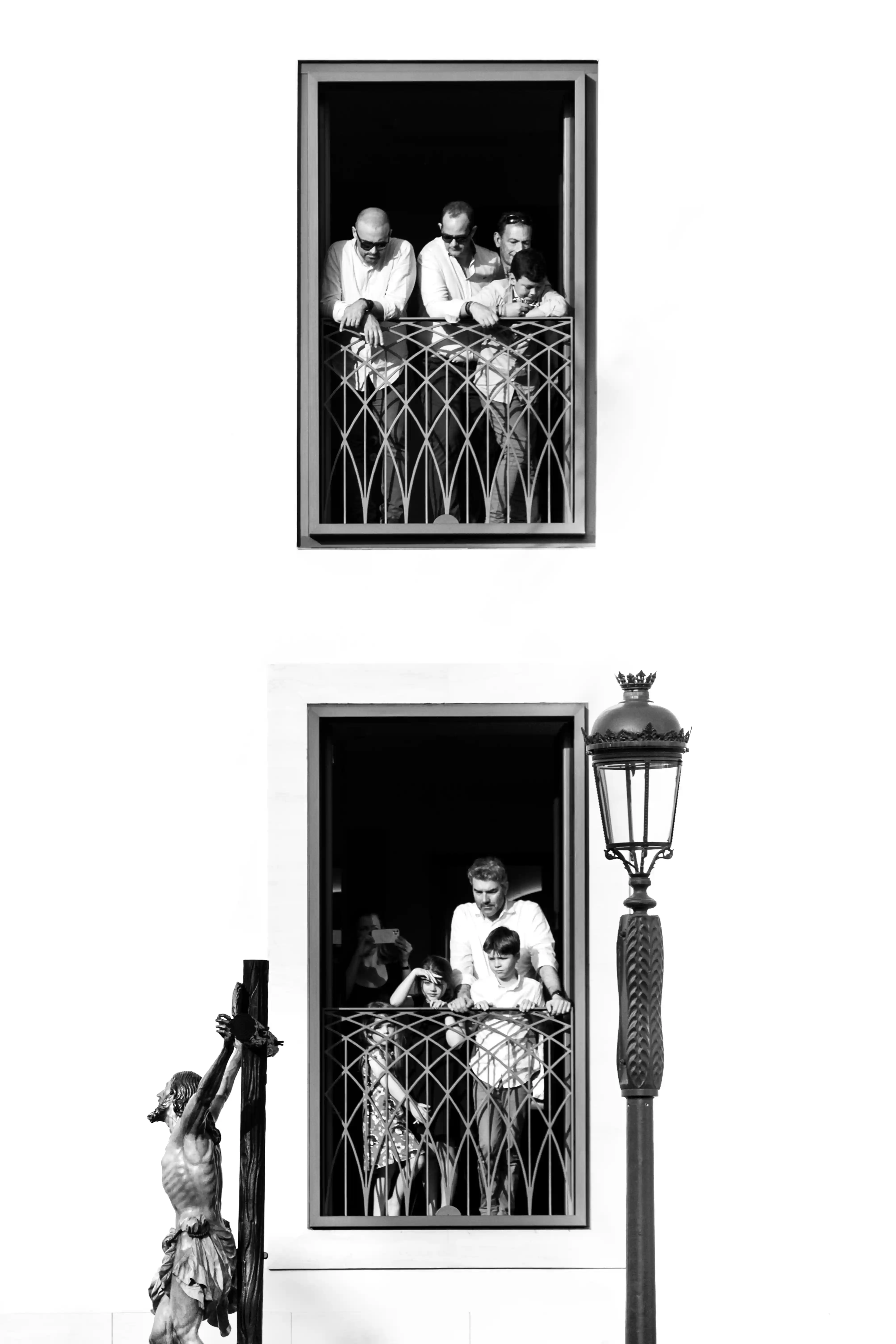 Primer premio 2022 concurso fotografía cofrade Hispano Happiness Club – balcones con espectadores y crucificado en blanco y negro.